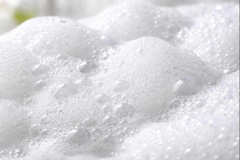 Person using shower pouf with shampoo