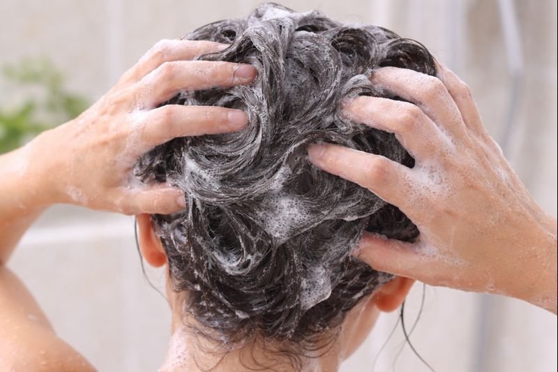 Person lathering shampoo in hair